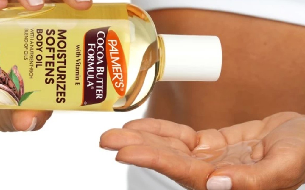women holding body oil pouring into hand